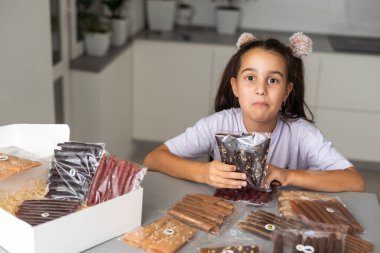 Bir kutu pastille küçük bir kız.