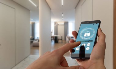 Akıllı ev otomasyon uygulaması arka planda iç mekan olan kadın eliyle akıllı telefondan tutulmuş. Yüksek kalite fotoğraf