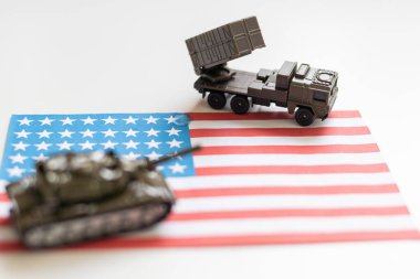 Amerikan bayrağı altında bir savaş uçağı, haki yeşili bir tank ve Amerikan bayrağında duran askeri bir araç. Yüksek kalite fotoğraf