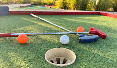 Sentetik çimlerin üzerinde golf topları olan renkli golf sopaları. Yüksek kalite fotoğraf