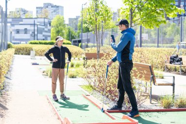 Genç ve yakışıklı bir baba küçük kızına golf oynamayı öğretiyor. Yüksek kalite fotoğraf