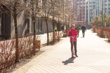 Parktaki bir yolda scooter süren küçük tatlı bir kız. Yüksek kalite fotoğraf