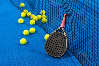 paddle tennis racket and balls on the blue paddle court. High quality photo clipart