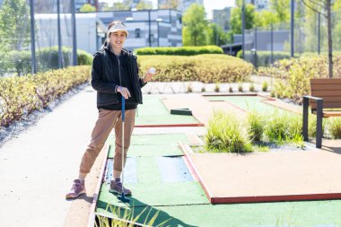 cute little girl on a miniature golf course. High quality photo clipart