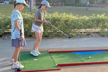 Genç kızlar mini golf oynarlar. Yüksek kalite fotoğraf