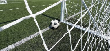 Açık hava futbol stadyumunda suni, parlak ve koyu yeşil çimlerde futbol topu. Yüksek kalite fotoğraf