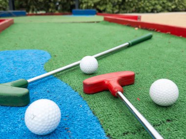 Sentetik çimlerin üzerinde golf topları olan renkli golf sopaları. Yüksek kalite fotoğraf