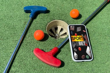 Yeşil çimenlikteki golf aletleri. Akıllı telefondan mini golf bahisleri. Yüksek kalite fotoğraf