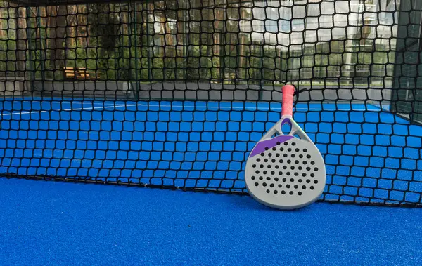 stock image Paddle tennis: Paddel racket and ball in front of an outdoor court. High quality photo