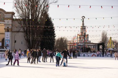KYIV, UKRAINE - 2 Ocak 2023: buz pateni insanları. İnsanlar buz pateni sahasında eğleniyor. Kyiv 'de yeni yıl tatili