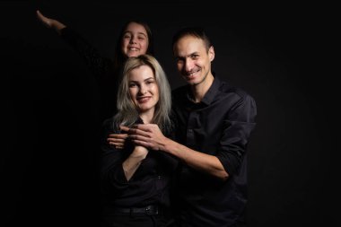 Sevimli küçük kız ve güzel ailesi kameraya bakıp gülümsüyor..