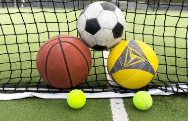 Spor sahasında çeşitli spor topları. Büyük turuncu bir basketbol topu, küçük siyah beyaz bir futbol topu. Yüksek kalite fotoğraf