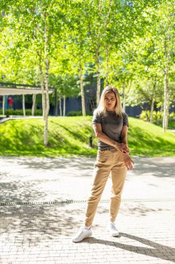 Genç sarışın kadın caddede kendine güvenen bir şekilde gülümsüyor. Yüksek kalite fotoğraf