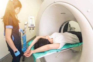 Modern bir hastanede bilgisayarlı tomografi tomografisi çektiren güzel, genç bir kadın..