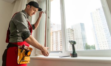 İçerideki pencereye lastik şerit takan bir adam. Yüksek kalite fotoğraf