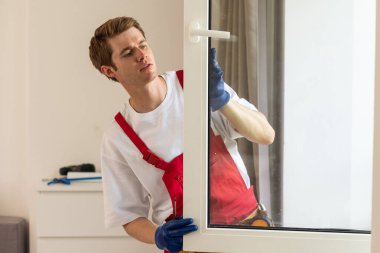 Yeni dairenin camlarını tamir eden bir tamirci.