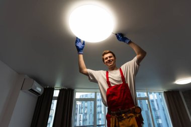 Yeni evin tavan lambasını değiştiren adam..