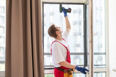 İnşaat işçisi eve pencere kuruyor