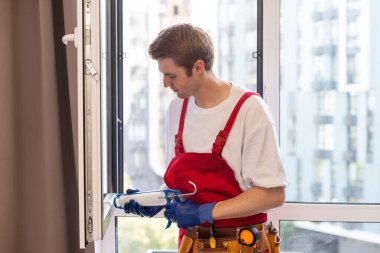 A repairman fixing windows in new apartment. clipart