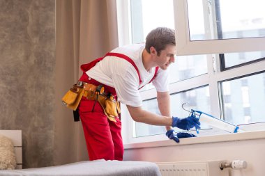 a repairman repairs, adjusts or installs metal-plastic windows in the apartment. glazing of balconies, loggias, verandas in house. production of double-glazed windows to individual sizes.