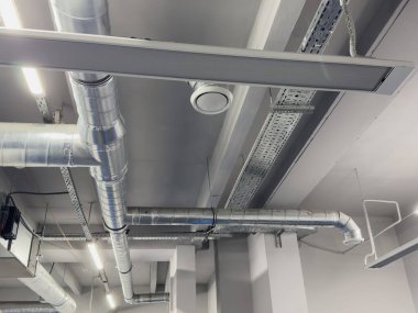 Metal borular endüstriyel bir işletmenin tavanında termal yalıtım yapıyor. Yüksek kalite fotoğraf
