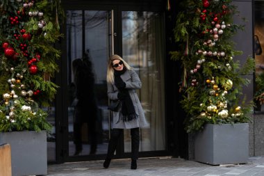 Muhteşem bir sarışın manken Noel tatilinde yerel alışveriş yapmak için sıcak bir günün tadını çıkarıyor. Yüksek kalite fotoğraf