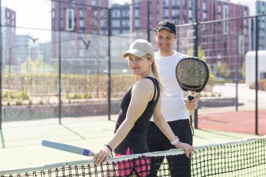 Mahkemede raketle padel oynayan zayıf bir kadın. Arkadan bak. Yüksek kalite fotoğraf