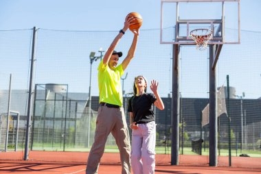 Baba ve kızı oyun alanında birlikte basketbol oynuyorlar. Yüksek kalite fotoğraf