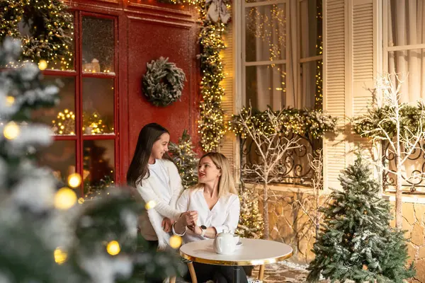 Genç anne, küçük çocuğuyla birlikte, sevimli küçük kızıyla birlikte, kış sıcacık kafesinde, Noel zamanı. Mutlu aile kucaklaşması, güzel bir kadın ve tatilde tatlı bir çocuk. Yüksek kalite fotoğraf