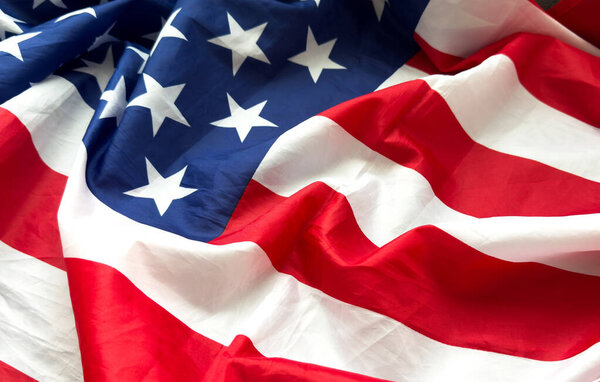 Крупный план взъерошенного американского флага. Атласная текстура искривленного флага США. День памяти или 4 июля. Знамя, концепция свободы. Высокое качество фото