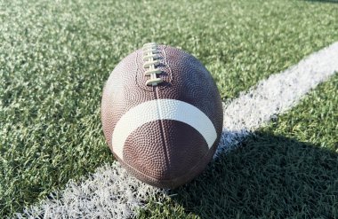 Yukardan görülen yeşil çimlerin üzerinde bir Amerikan futbol topu. Yüksek kalite fotoğraf