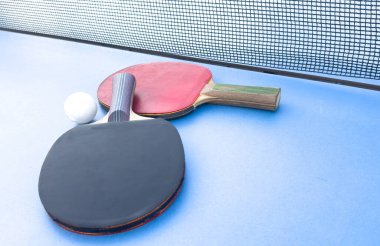 iki pinpon raketi ve yeşil masada bir top. Yakın plan, pinpon ağı. Yüksek kalite fotoğraf