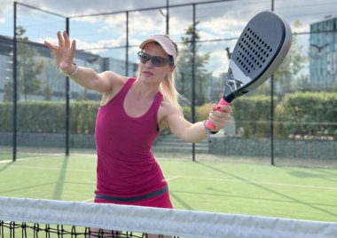 Padel tenisinde Avrupalı genç bayan tenisçi dışarıda oynanan dostça çiftler maçında oynuyor. Yüksek kalite fotoğraf