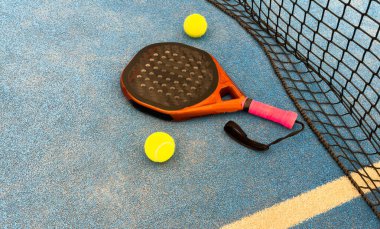 Padel raketi mavi bir kortta top ile. Yüksek kalite fotoğraf
