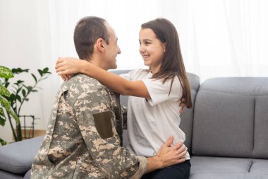 Askeri üniformalı genç bir adam ve karısı evdeki kanepede. Yüksek kalite fotoğraf
