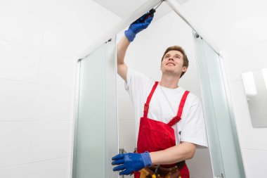 Tesisatçı silikon kartuş duş kabinin alüminyum çıta sabitleme kullanarak.