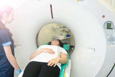 Bilgisayarlı tomografi tarayıcısındaki hastayı ameliyat hazırlıkları sırasında gözden kaçıran CT tarama teknolojisi uzmanı. Kadın hasta tomografiye giriyor.