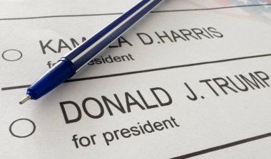Ukrayna Kyiv, 19 Eylül 2024: Donald J. Trump ile Kamala D. Harris arasında seçmen oylamasının basılı temsili üzerine bir kalem havada asılı kaldı. Yüksek kalite fotoğraf