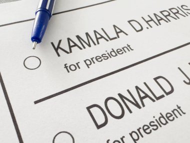 Ukrayna Kyiv, 19 Eylül 2024: Donald J. Trump ile Kamala D. Harris arasında seçmen oylamasının basılı temsili üzerine bir kalem havada asılı kaldı. Yüksek kalite fotoğraf