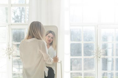 Kendine güveni tam bir kadın aynadaki yansımasına bakıyor. Güzel iç tasarım. Yüksek kalite fotoğraf