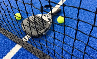 Padel raketi mavi bir kortta top ile. Yüksek kalite fotoğraf