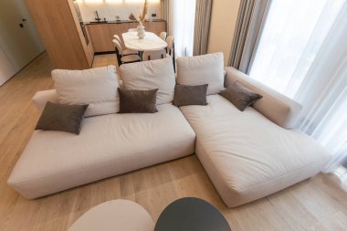 Odanın ortasında beyaz duvarları ve ahşap döşemeleri olan bir oturma odası var. Yüksek kalite fotoğraf