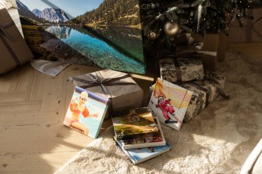 Noel ağacının altında Noel hediyeleriyle çevrili bir fotoğraf kitabı albümü. Yüksek kalite fotoğraf