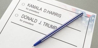 Ukrayna Kyiv, 19 Eylül 2024: Donald J. Trump ile Kamala D. Harris arasında seçmen oylamasının basılı temsili üzerine bir kalem havada asılı kaldı. Yüksek kalite fotoğraf
