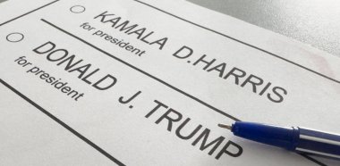Ukrayna Kyiv, 19 Eylül 2024: Donald J. Trump ile Kamala D. Harris arasında seçmen oylamasının basılı temsili üzerine bir kalem havada asılı kaldı. Yüksek kalite fotoğraf