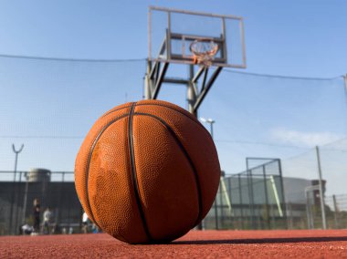 Dış sahada basketbol topu, arka planda çember var. Spor malzemeleri. Yüksek kalite fotoğraf