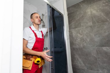 Tesisatçı banyoya duş kabini kuruyor. Yüksek kalite fotoğraf