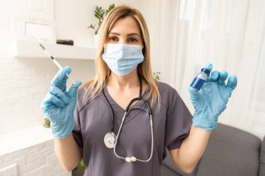 Araştırmacıların ellerinde COVID-19 aşısı, kadın doktorlar Coronavirus tedavisi için şırınga ve şişe tutuyorlar. Salgın sırasında korona virüsü tedavisi, enjeksiyon, iğne ve klinik deney kavramı