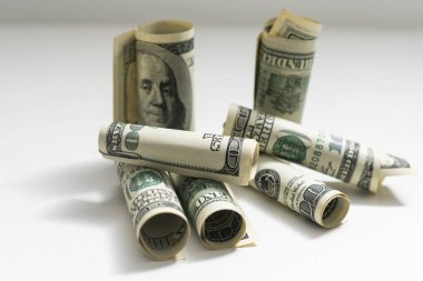 roles dollar notes in front of white background.