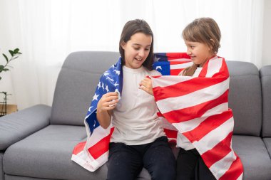 Neşeli sevimli çocuklar Amerikan bayrağı altında dikilip bakıyorlar. Yüksek kalite fotoğraf